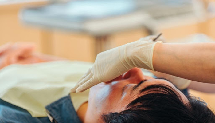 歯科医院で口腔内チェックをうける男性の患者さま