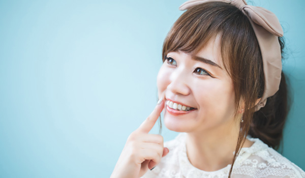 歯を指さす女性