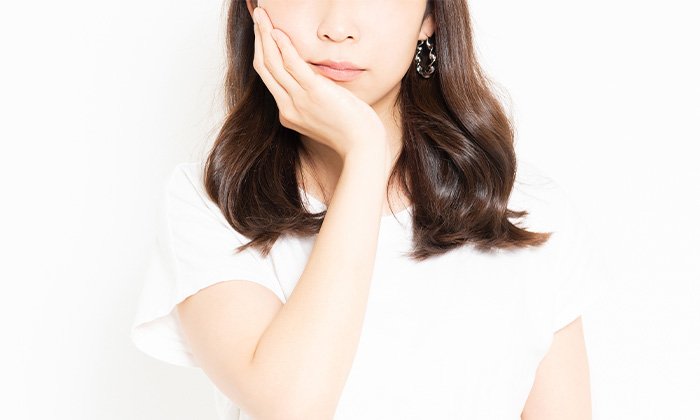 顎をおさえる女性