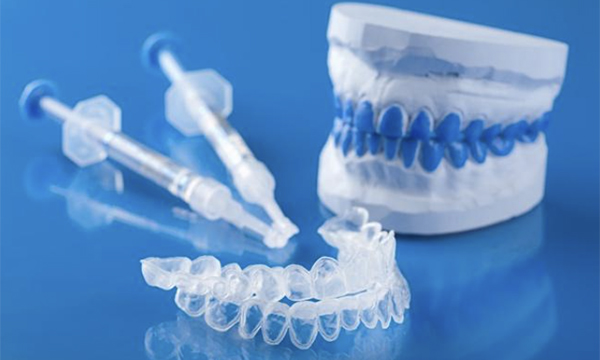 歯型の模型とホームホワイトニングジェル、ホームホワイトニングトレーの写真