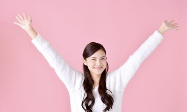 両腕をあげ喜ぶ女性