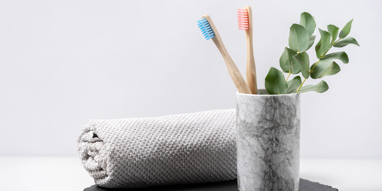 タオルとコップに入った2本の歯ブラシの写真