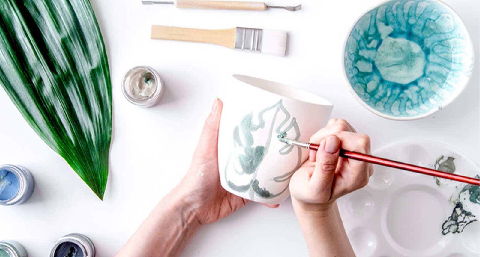 陶器のマグカップにイラストを描いている様子