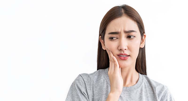 痛みに顔を歪ませ、頬をおさえる女性