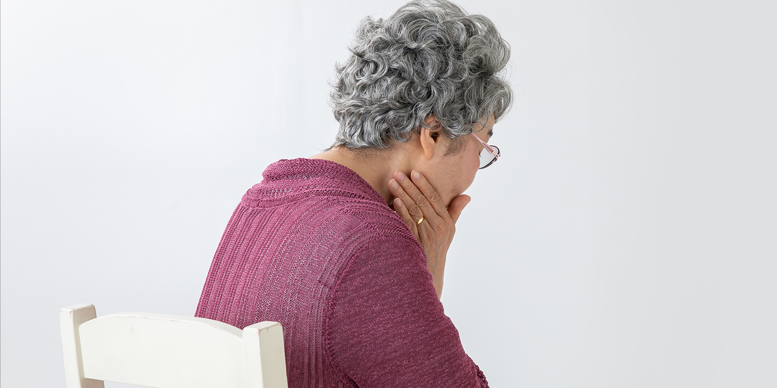 顎を押さえる老人