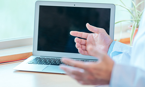 パソコンの前で説明している歯科医師のイメージ