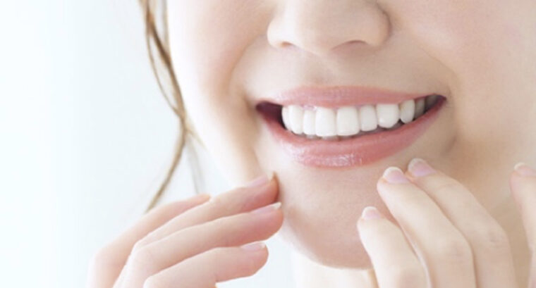 口元に両手を近づけて白い綺麗な歯を見せて微笑む女性の口元