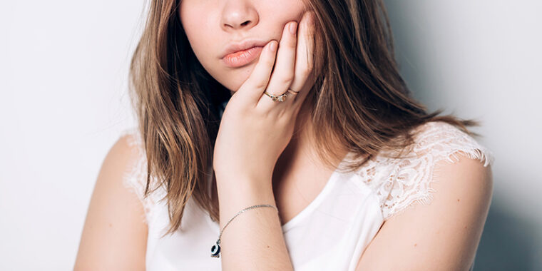 顎をおさえる女性